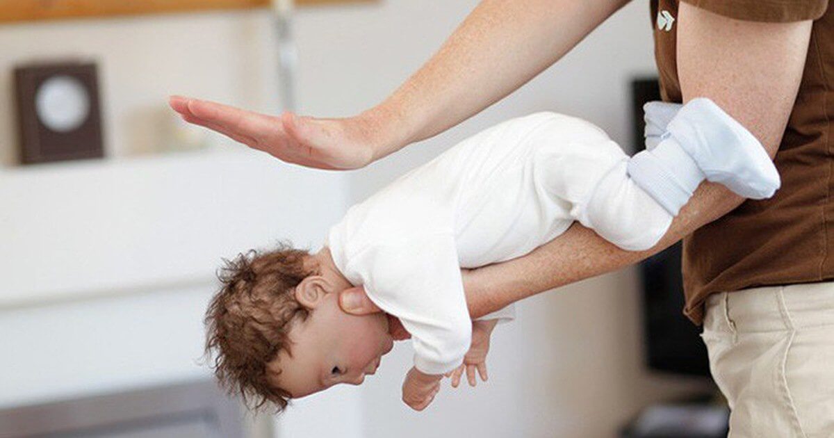Đặt trẻ nằm sấp trên lòng bàn tay và dùng lòng bàn tay còn lại vỗ vào giữa 2 xương bả vai của trẻ